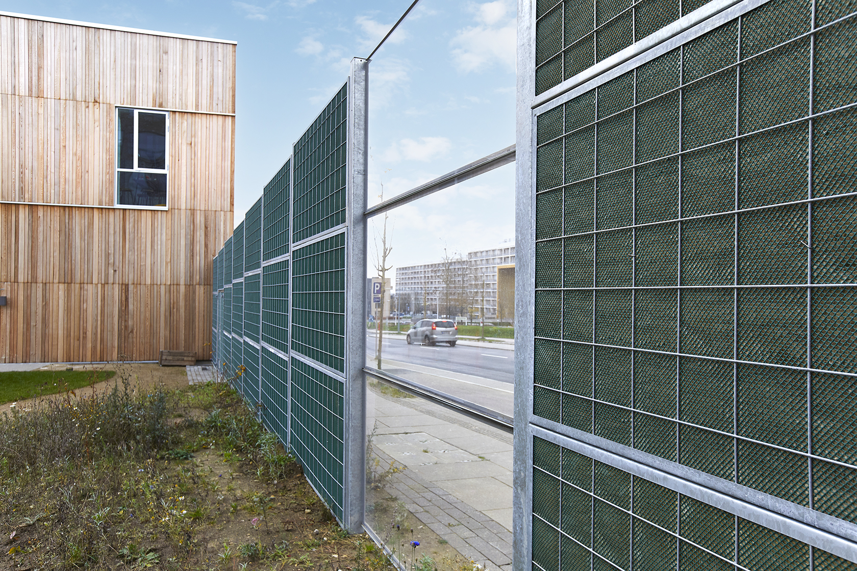 Noistop Steel barrier with transparent panel along a school and residential street