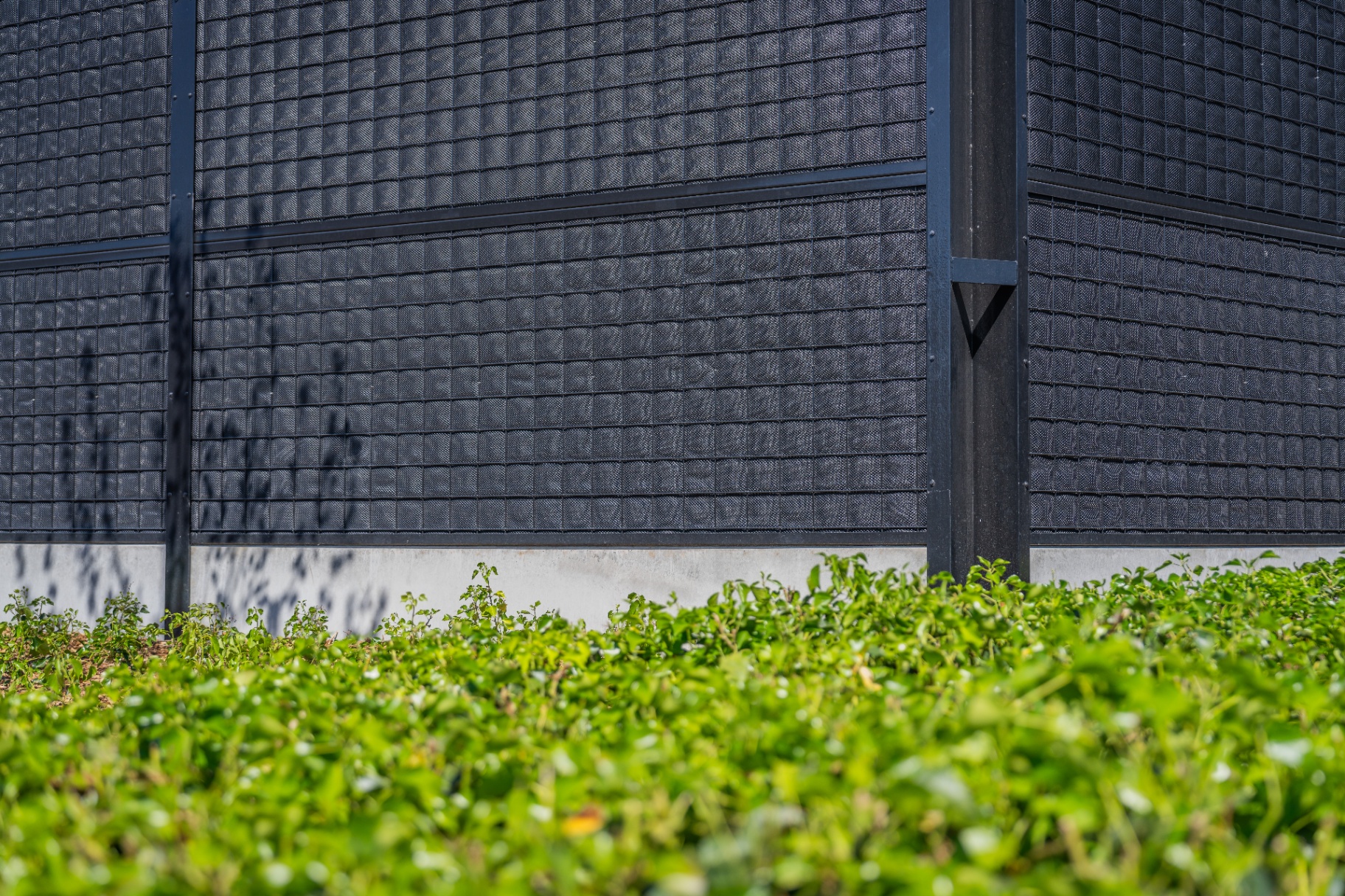 Close-up of Noise-Reducer panels with absorbent structure and steel frame, mounted on a concrete base