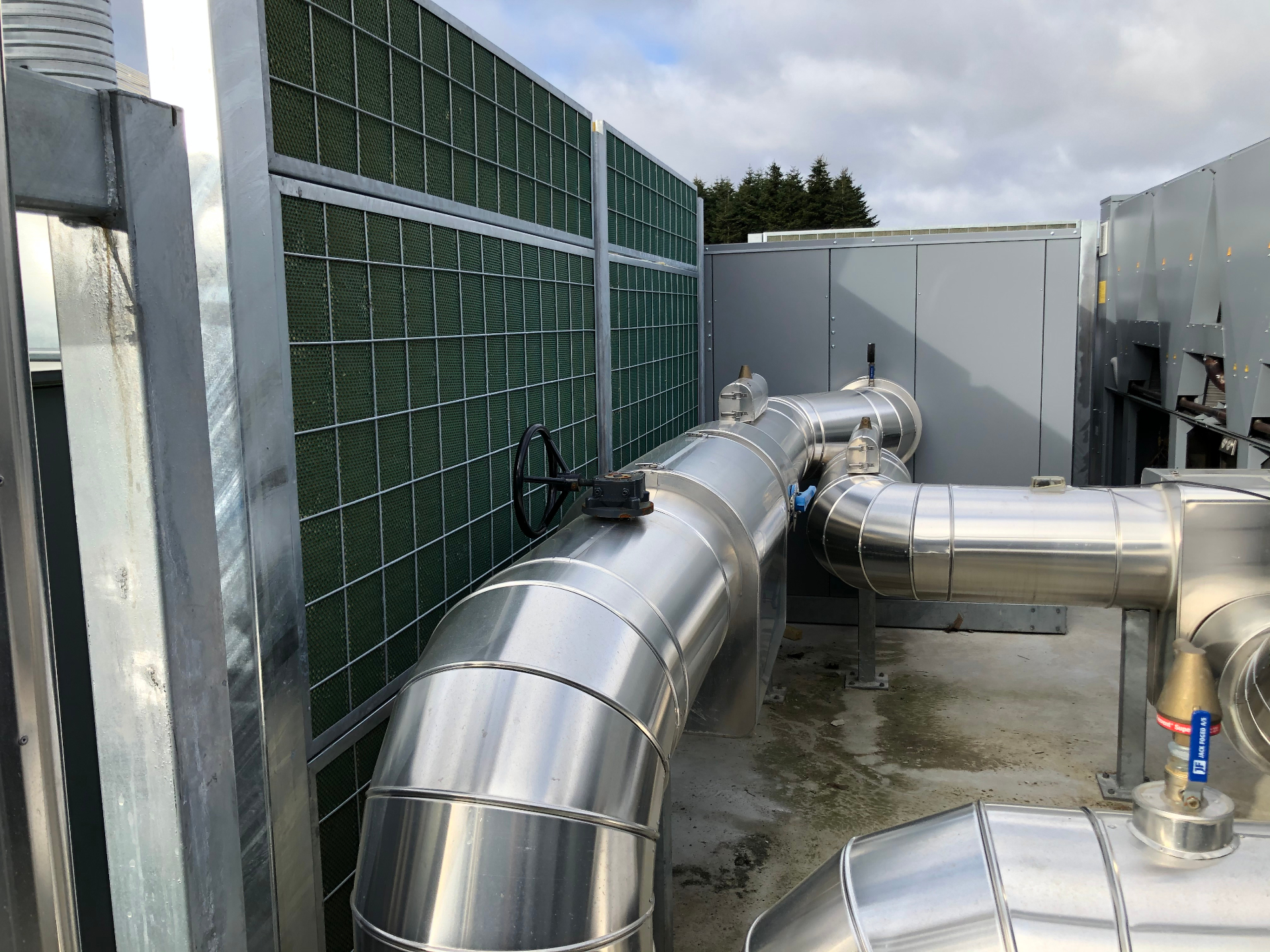 Noistop Steel barrier on an industrial rooftop shielding pumps and machinery