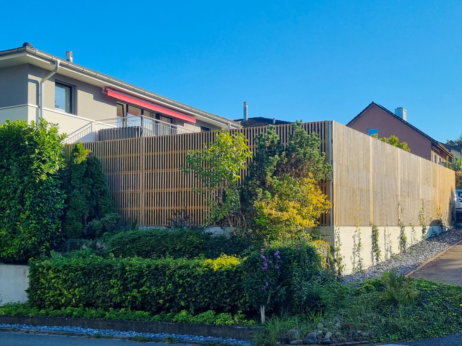 Tall Noistop Essential barrier in natural wood along the street of a residential home in Germany