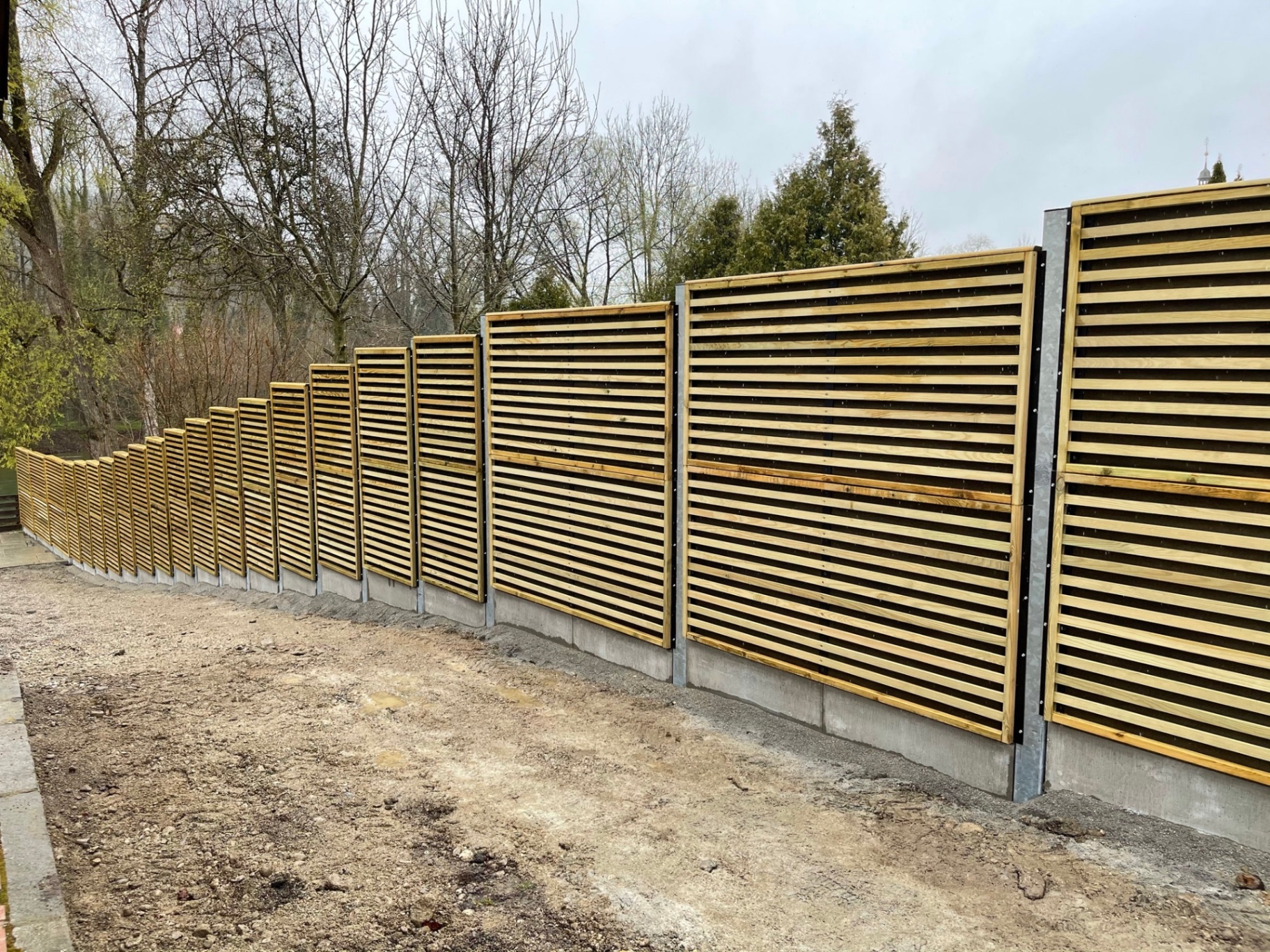 Stepped Noistop Wood barrier following a slope in a residential garden