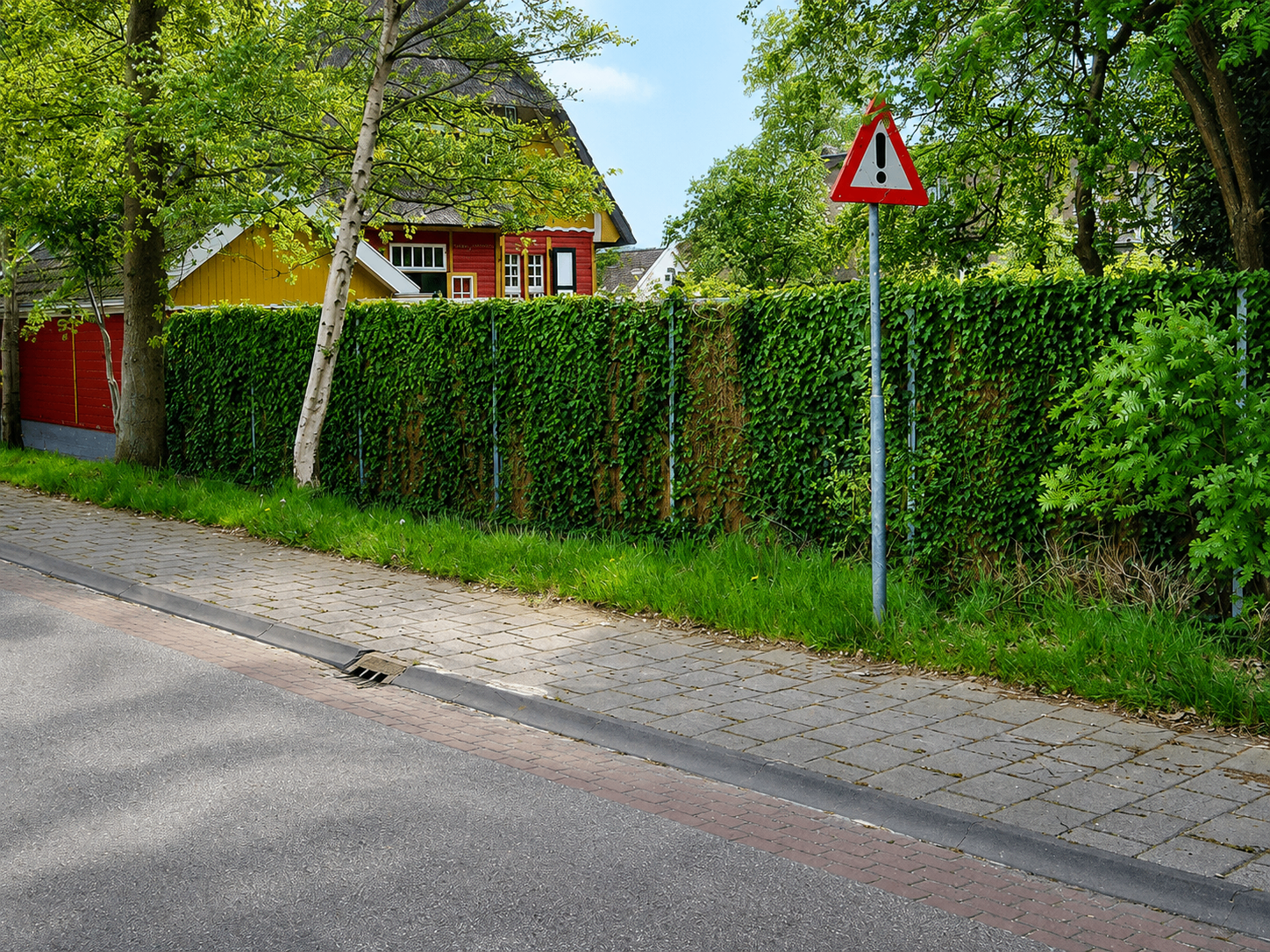 Écran anti-bruit Kokowall entièrement recouvert de lierre, intégré comme haie verte dans une rue résidentielle