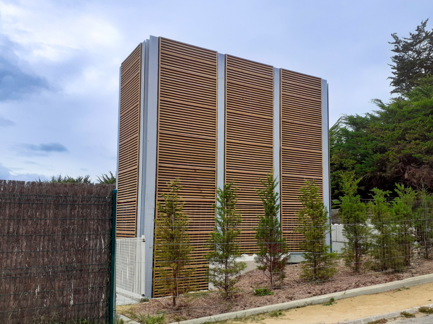 Tall Noistop Wood tower in natural Elba pine next to a pool park fence