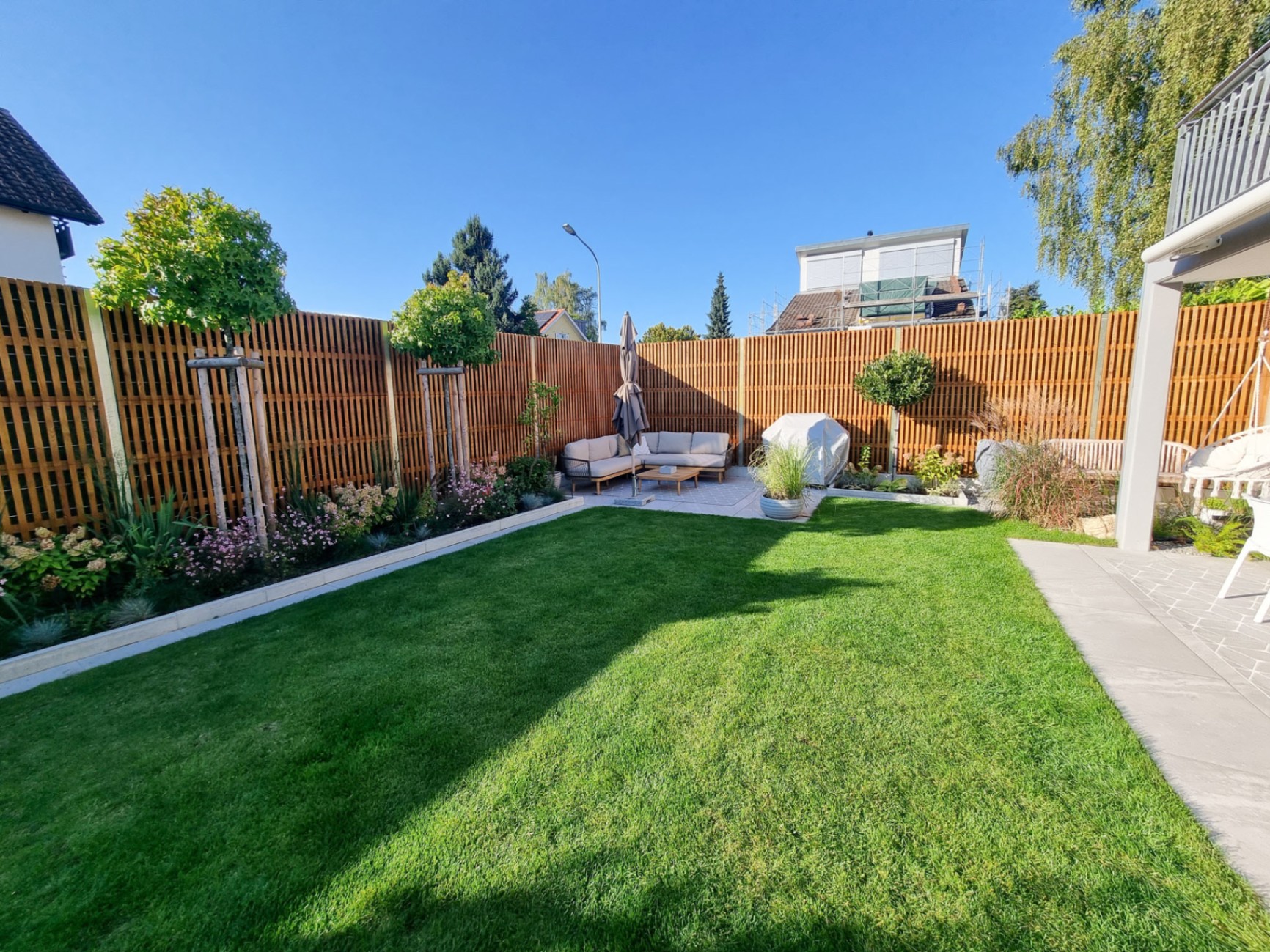 Noistop Essential noise barrier around a landscaped private garden with terrace and lawn