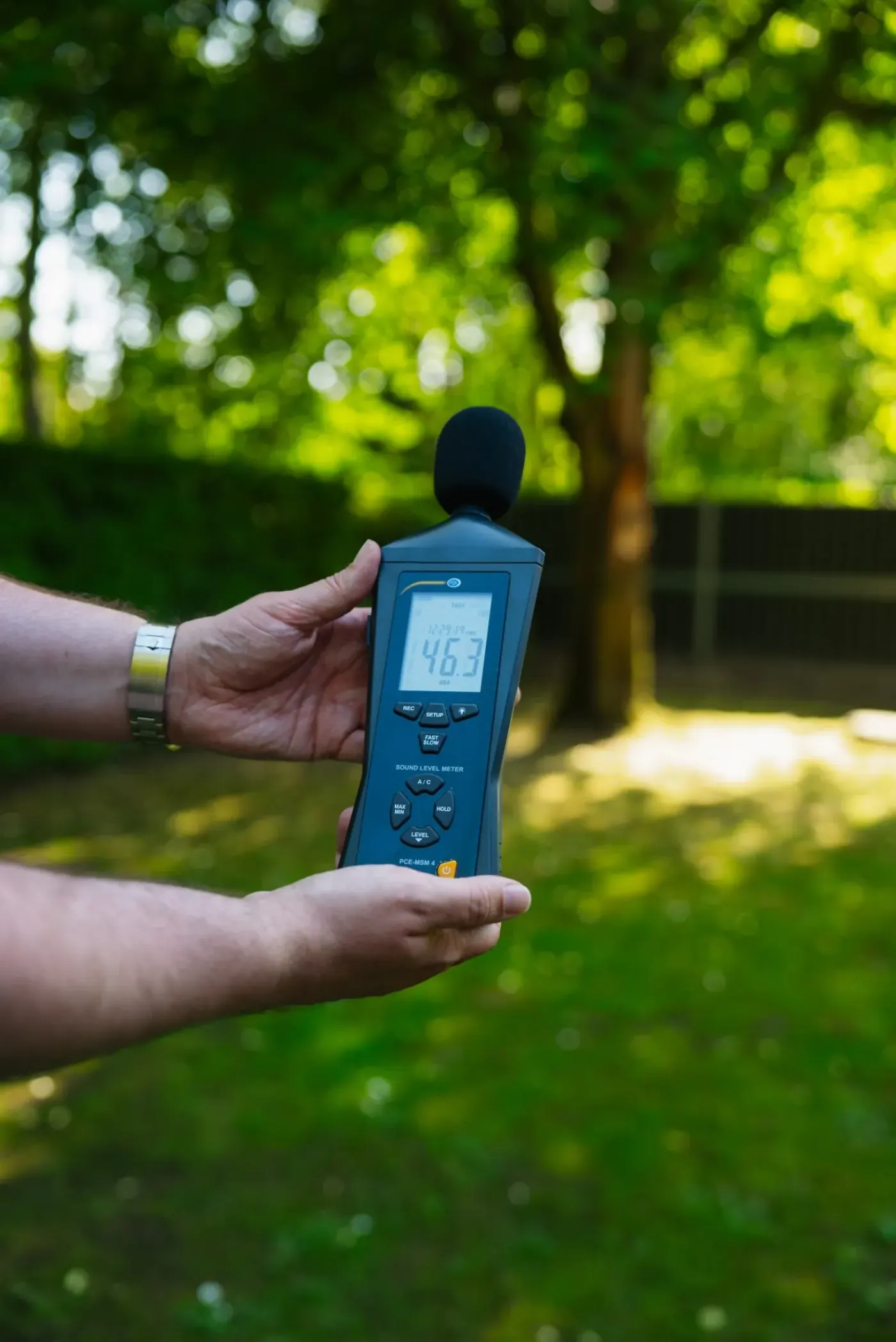Sound level meter shows 46 dB for traffic behind a Noise Solutions sound barrier